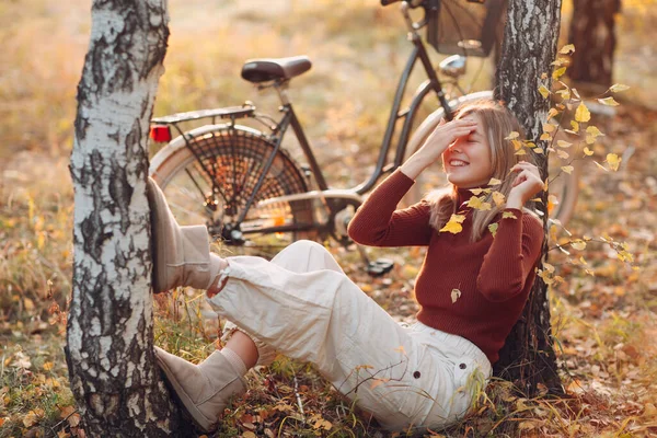 Happy active młoda kobieta siedzi z vintage rower w jesiennym parku o zachodzie słońca — Zdjęcie stockowe