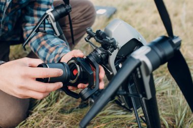 Erkek pilot, havadan uçmadan önce kuadkopter drone 'u kontrol ediyor..