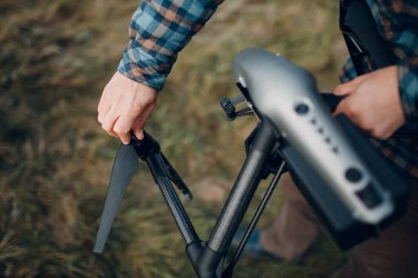 Erkek pilot, havadan uçmadan önce kuadkopter drone 'u kontrol ediyor..