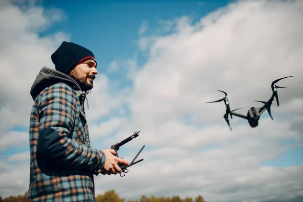 Hombre piloto que controla el dron quadcopter con control remoto pad — Foto de Stock