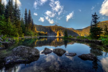 Clear lake, pine trees and mountains clipart