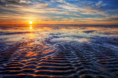 Gün batımı sırasında kum üzerinde eğrileri