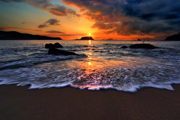 Sunset over an ocean beach shore — Stock Photo, Image