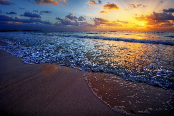 Solnedgang over en strand ved havet – stockfoto