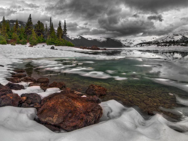 Riva del lago di montagna quasi ghiacciata — Foto Stock