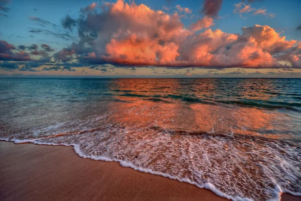 Puesta de sol sobre una orilla de playa del océano —  Fotos de Stock