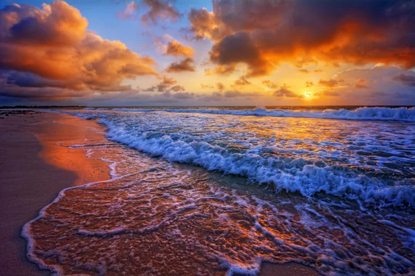 Puesta de sol sobre una orilla de playa del océano — Foto de Stock