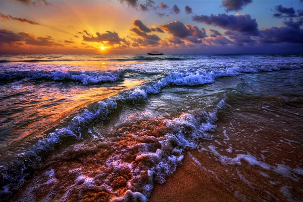 Puesta de sol sobre una orilla de playa del océano — Foto de Stock