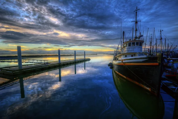 Лодки на облачном восходе солнца на пристани — стоковое фото
