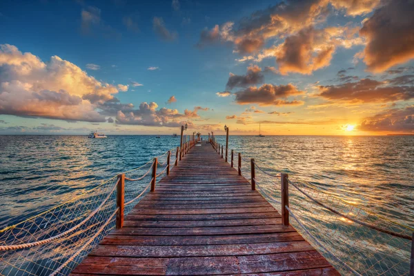 Nascer do sol brilhante em um cais do mar — Fotografia de Stock