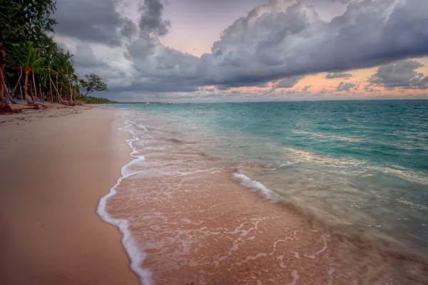 Bølger som kryper på en sandstrand – stockfoto