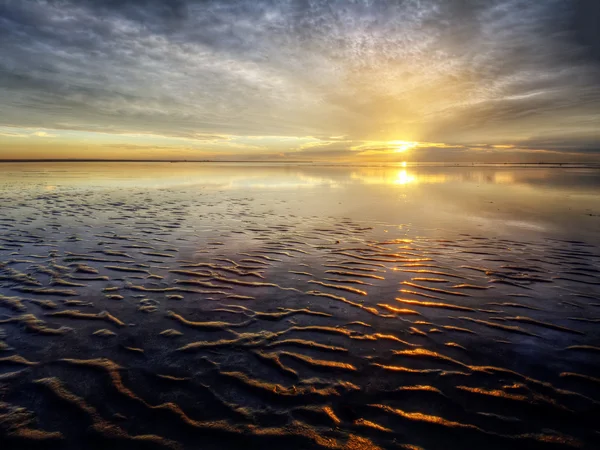 Криві на піску під час заходу сонця — стокове фото