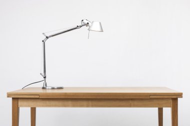 Alüminyum aydınlatma beyaz izole ahşap desk(table) üzerinde durmak.