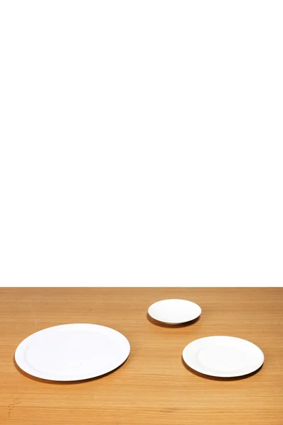 Le bureau en bois (table) avec plat blanc isolé blanc . — Photo