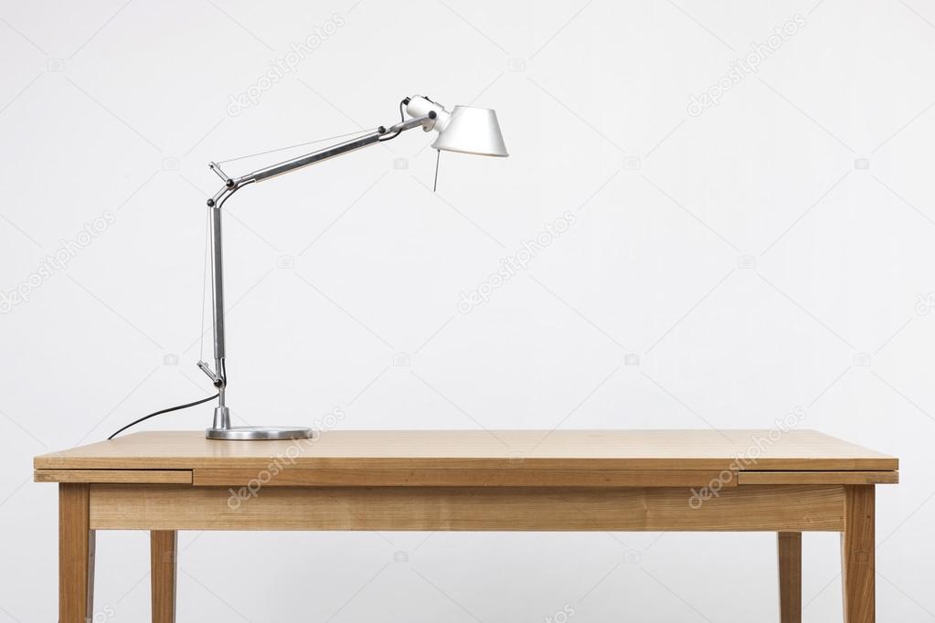 A aluminum lighting stand on the wood desk(table) isolated white.