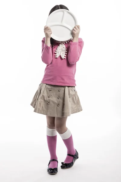 Uma menina (criança) segurando um prato branco — Fotografia de Stock