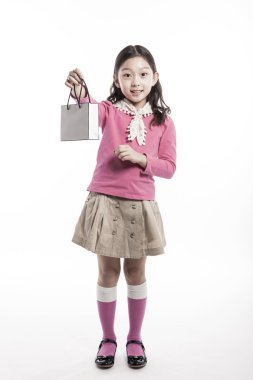 Bir çocuk giymiş pembe bluz, beyaz eşarp kese kağıdı ile.