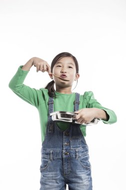 Bir çocuk yemek tepsisi ile mutfakta.