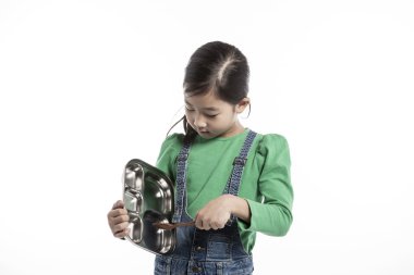 Bir çocuk yemek tepsisi ile mutfakta.