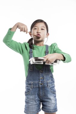 Bir çocuk yemek tepsisi ile mutfakta.