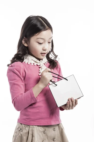 Un niño con blusa rosa, bufanda blanca con bolsa de papel . —  Fotos de Stock