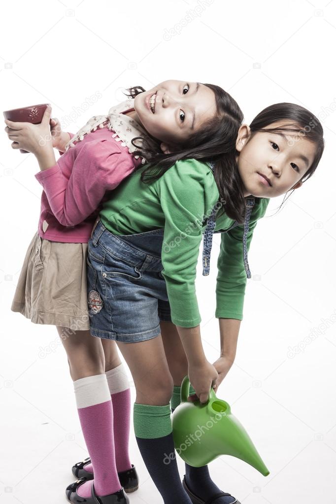 Two kids(girl) with watering tool, pot