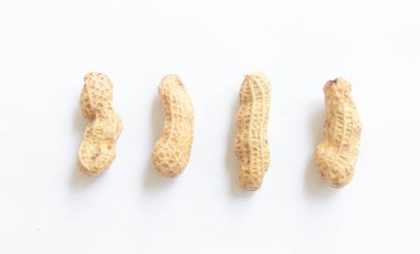 Temiz beyaz arka plana yerleştirilmiş kabuklu çiğ fıstık yığını. Gıda malzemeleri, tarım ürünleri, sağlıklı atıştırmalıklar veya fındıkla ilgili konular için idealdir..