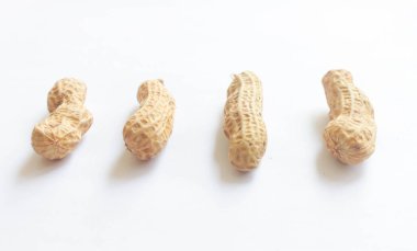 Temiz beyaz arka plana yerleştirilmiş kabuklu çiğ fıstık yığını. Gıda malzemeleri, tarım ürünleri, sağlıklı atıştırmalıklar veya fındıkla ilgili konular için idealdir..