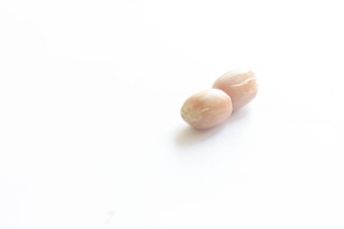 Temiz beyaz arka plana yerleştirilmiş kabuklu çiğ fıstık yığını. Gıda malzemeleri, tarım ürünleri, sağlıklı atıştırmalıklar veya fındıkla ilgili konular için idealdir..