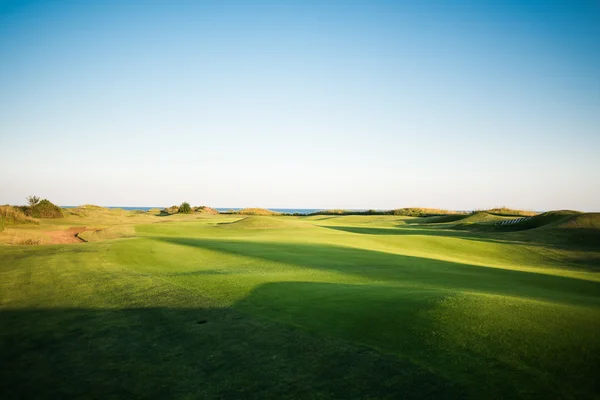 Golfbana med sand fällor vid solnedgången — Stockfoto