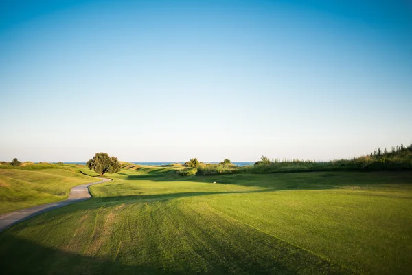 Sétány közelében golfpálya naplementekor — Stock Fotó