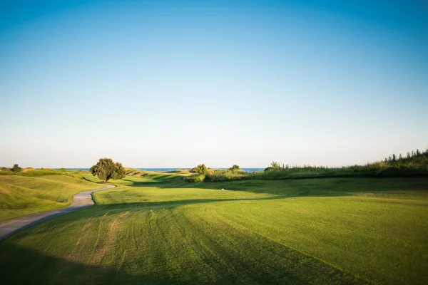 Gångväg nära golfbana vid solnedgången — Stockfoto