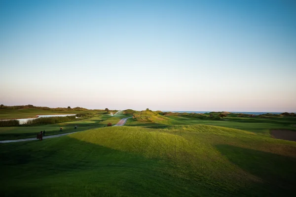 Прогулянка біля поля для гольфу на заході сонця — стокове фото