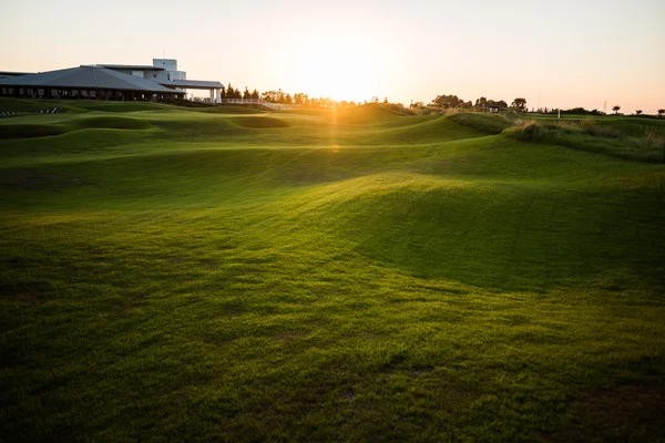 Golf clubhuis met stralen van de zon bij zonsondergang — Stockfoto