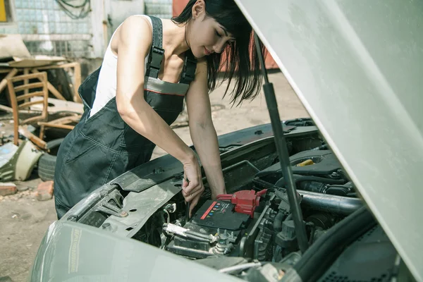  Kadın araba mekanikçi araba motorunun onarır 