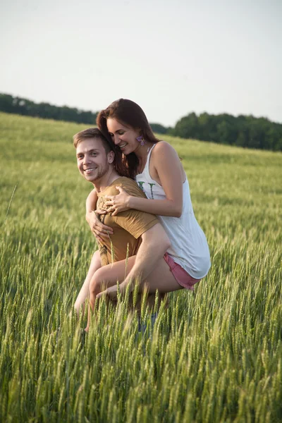 Un hombre que le da a su novia una espalda a cuestas —  Fotos de Stock