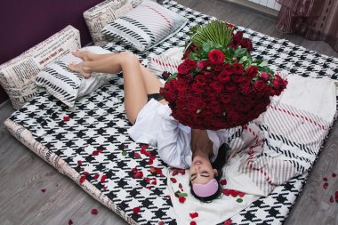  girl laying in bed  with roses