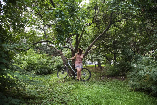 Chica de pie con una bicicleta — Foto de Stock