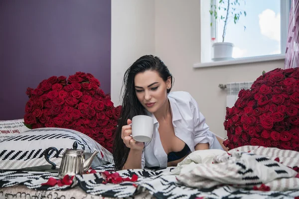 Tjej dricka te i sängen — Stockfoto