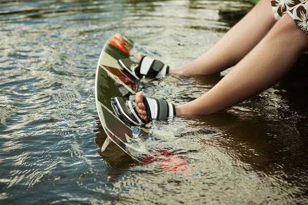 Mäns fötter på en wakeboard i vatten — Stockfoto