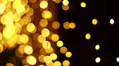 Karanlık bir arkaplanda soyut altın bokeh ışıkları