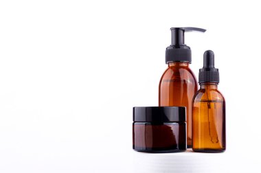 Pompa şişesi, damlalık şişesi ve kavanoz da dahil olmak üzere kehribar cam kaplar koleksiyonu, doğal güzellik ürünleri veya gerekli yağları öneriyor.