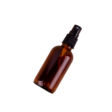 Siyah pompalı tek bir kehribar cam sprey şişesi siyah arka planda izole edilir, ürün kullanımına hazırdır.