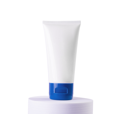 Minimalist bir stüdyo çekiminde açık mor silindirik bir duruşta sunulan parlak mavi kapaklı beyaz sıkma tüpü ürün modellemeleri için mükemmel olan koyu siyah bir arka planda yer alır.