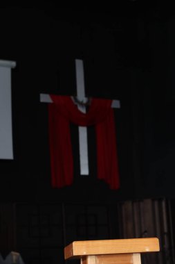 Dikenli bir taç ve canlı kırmızı kumaşla süslenmiş, Paskalya ve Büyük Perhiz temalarını çağrıştıran kutsal bir haç sembolü.