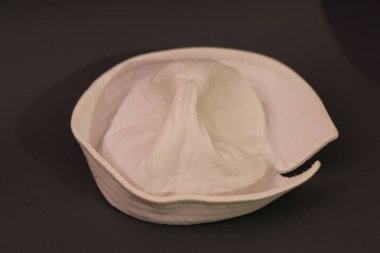 Geleneksel beyaz denizci şapkası, genellikle dixie cup şapka olarak adlandırılır, berraklık için düz koyu bir zemin üzerinde sunulur.