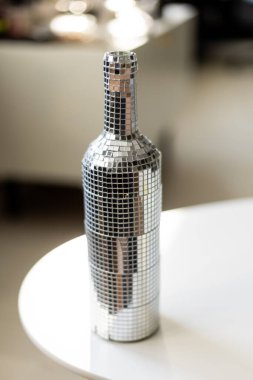 Aynalı mozaik fayanslarla kaplı dekoratif bir şişe ışığı yansıtır, her kutlama ve olay için şenlikli ve büyüleyici bir atmosfer yaratır.