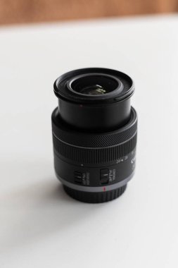 Bu detaylı çekimde, temiz ve minimalist bir arkaplana karşı yapısını ve kontrol unsurlarını vurgulayan yüksek kaliteli bir kamera merceği görülüyor.