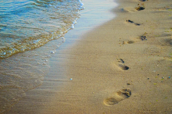 Hullámok és a homok lábnyomok — Stock Fotó