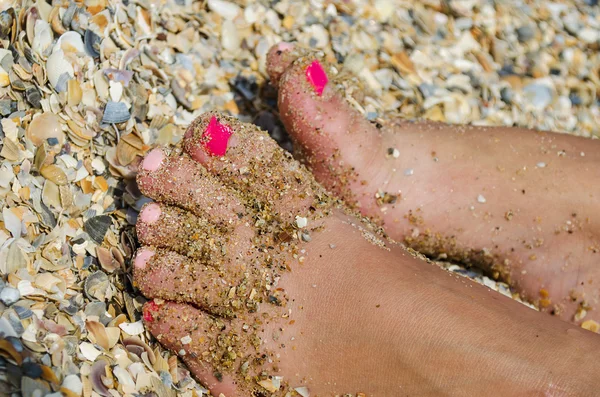 Piernas femeninas en la playa de grava y arena —  Fotos de Stock